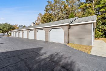 a row of garages with white doors in a parking lot